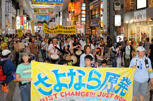 「さよなら原発」と書かれた横断幕を掲げ、アーケード街を行進する市民ら＝１１日午後３時すぎ、熊本市