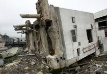 津波で基礎部分のくいごと横倒しになった石巻署女川交番＝１２日